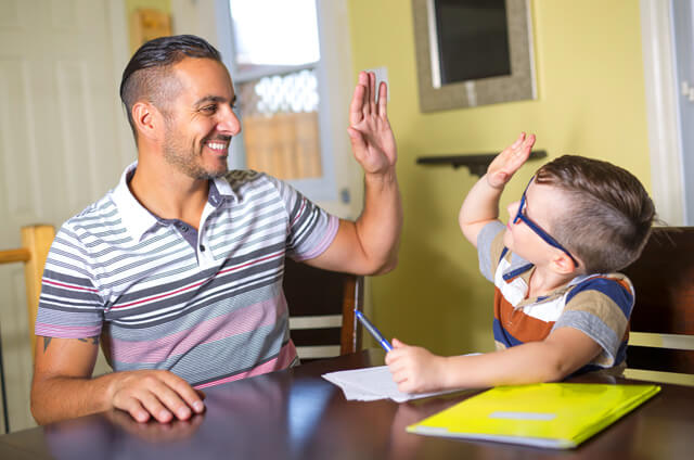 Nachhilfelehrer und Schüler lernen gemeinsam am Tisch in Berlin