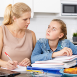Mutter und Tochter bei Hausaufgaben am Tisch in Berlin