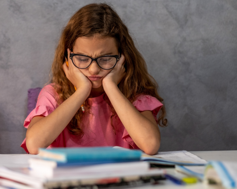 Schülerin sitzt frustriert am Tisch und kommt beim Lernen nicht weiter